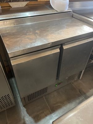 a stainless steel counter with two freezers and a roll of toilet paper on it