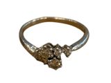 une image représentant une bague en or ornée de deux crânes
