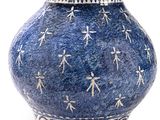 un vase bleu orné de motifs blancs sur fond blanc