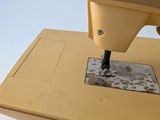 a yellow sewing machine that is sitting on a table