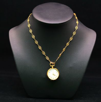 un gros plan d'un collier orné d'une horloge, porté par un mannequin