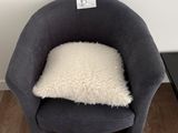 une petite chaise sur laquelle est posé un coussin, dans une pièce