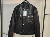 une veste en cuir noir accrochée à un portant dans une pièce