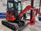 a small red excavator parked inside of a building