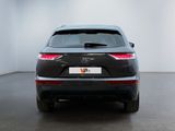 the rear end of a black suv parked in a white room