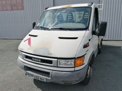 une camionnette blanche garée devant un immeuble sur lequel figure une flèche rouge