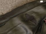 a black leather jacket with a brown belt on the floor