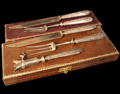 cinq couteaux et une fourchette dans une boîte posée sur une table