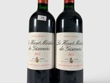 deux bouteilles de vin rouge posées l'une à côté de l'autre sur une surface blanche