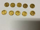 a bunch of gold coins sitting on top of a white table