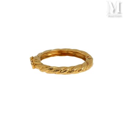 gros plan d'une bague en or sur fond blanc