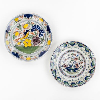 deux assiettes sur lesquelles sont peints des fleurs et des oiseaux sur un fond blanc