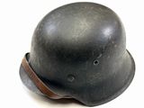 an old helmet with a leather band on a white surface