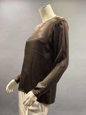 une photo d'un mannequin portant un haut marron et un pantalon blanc