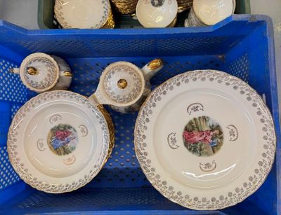 many plates and cups in a basket on the table
