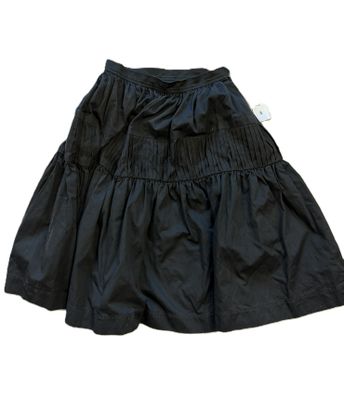 La jupe est noire et comporte une étiquette blanche.