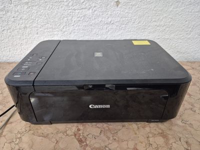 une imprimante Canon posée sur une table près d'un mur