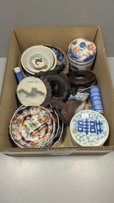 une boîte remplie d'assiettes et de bols en porcelaine posée sur une table