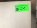 a box with a label on it sitting next to a bed