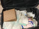 a black suitcase filled with items sitting on a tiled floor