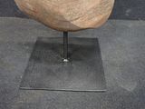 a stone object on a stand on a black surface