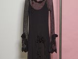 dress hanging on a hanger in front of a pink wall