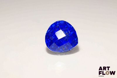a close up of a blue sapphire stone on a white surface