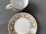 two cups and a saucer are sitting on a table