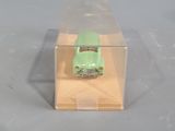 a green toy car in a clear box on a table