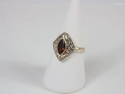 a close up of a ring with a red stone in it