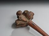 a wooden stick with a flower on it on a white surface