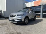 un SUV Buick argenté garé devant un immeuble