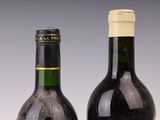 two bottles of wine sitting next to each other on top of a table