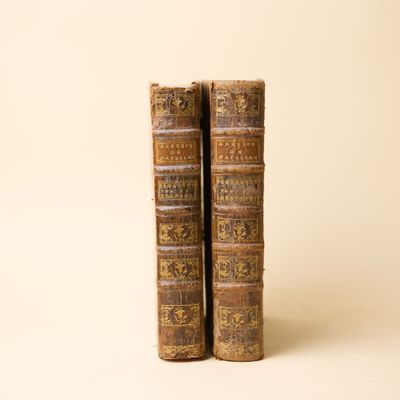 deux vieux livres posés l'un sur l'autre sur une surface blanche