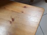 a cat sitting on a wooden table in the kitchen
