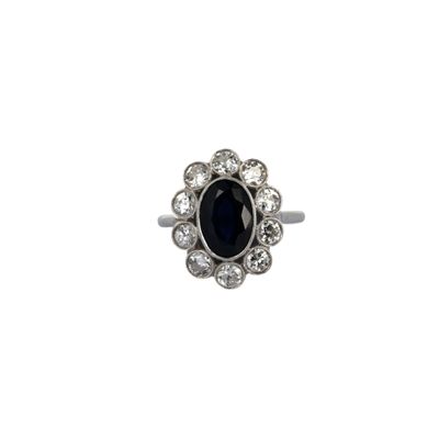 gros plan d'une bague avec une pierre noire entourée de diamants blancs