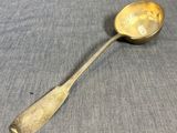 an antique spoon with a smiley face on it sitting on a table