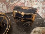 a black and gold table with a cup and saucer on it