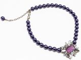 un gros plan sur un collier orné de perles violettes et d'une fleur