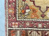 an old rug with a red and yellow border on a blue surface