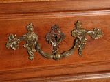 a close up of a wooden dresser with brass handles