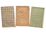 three small notebooks are lined up on a white surface