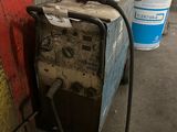 an image of a welding machine in a garage with a red wall