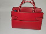 un sac à main rouge posé sur une table blanche