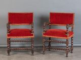 une paire de chaises rouges placées l'une à côté de l'autre sur un sol en béton