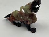 figurine of a horse with a rider on its back on a white surface