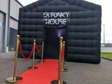 a giant inflatable house with a red carpet on the ground
