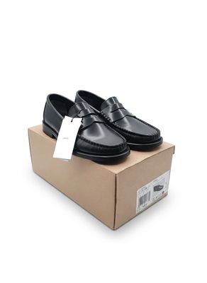Mocassins noirs pour homme présentés dans une boîte sur fond blanc