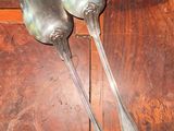 two spoons sitting on a wooden table next to each other