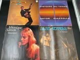 three records on a table with a guitar in front of them